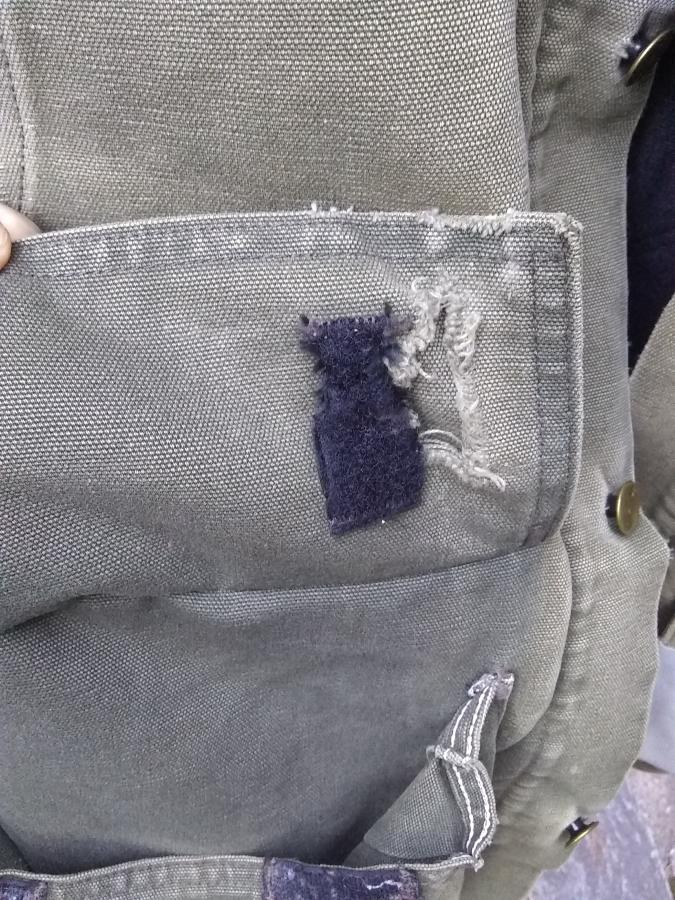 Pocket of jacket with hole and worn-out velcro