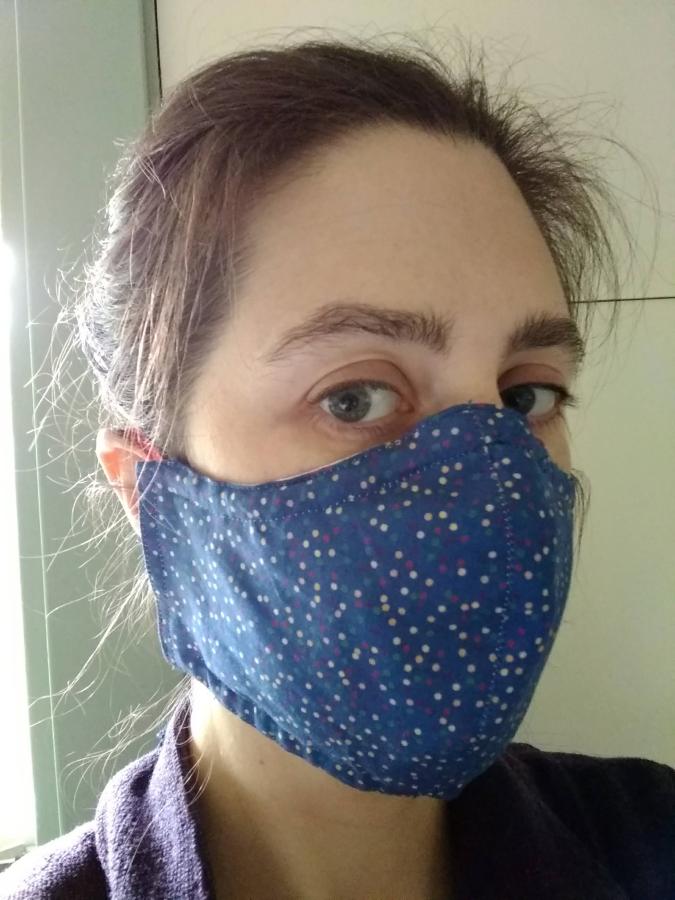 Woman wearing fitted blue polka dot face mask