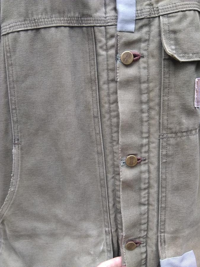 closeup of several mended buttonholes on a Carhartt jacket