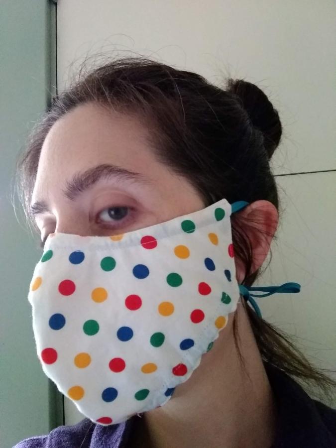 side view of woman wearing multi/white polka dot fitted face mask