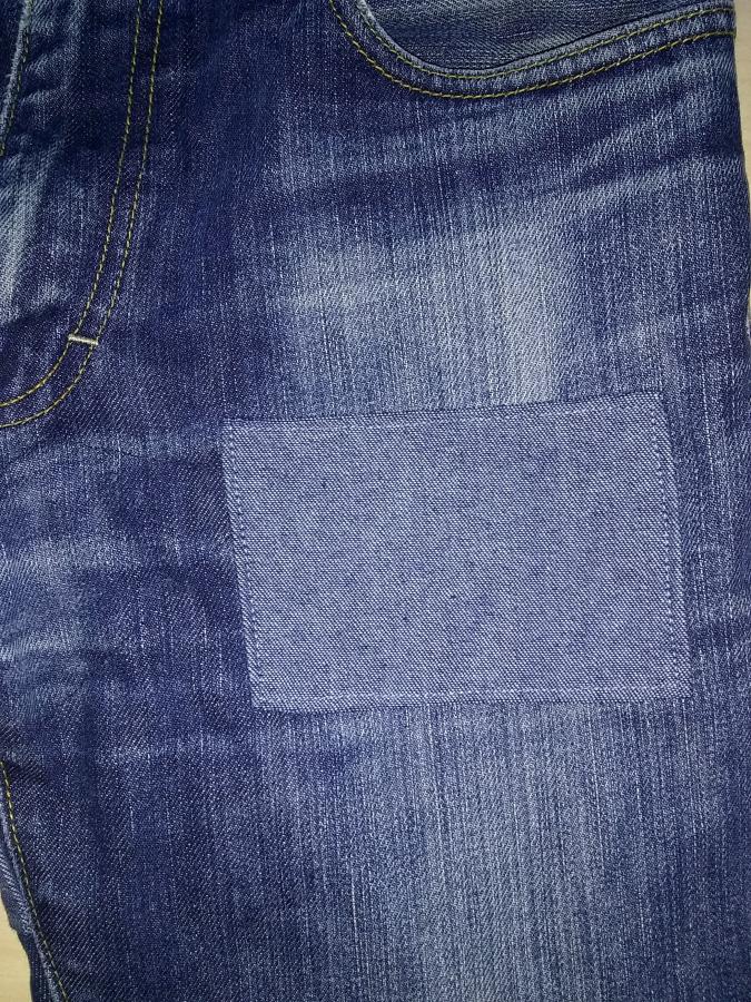 Right front of jeans with a denim patch sewn on a few inches below the pocket