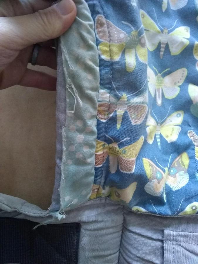 closeup of ripped fabric on baby carrier, front view