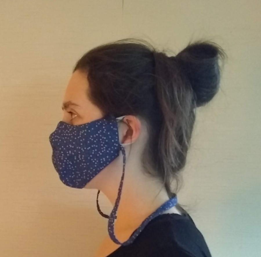 side view of woman wearing fitted face mask with elastic ear loops and neck cord