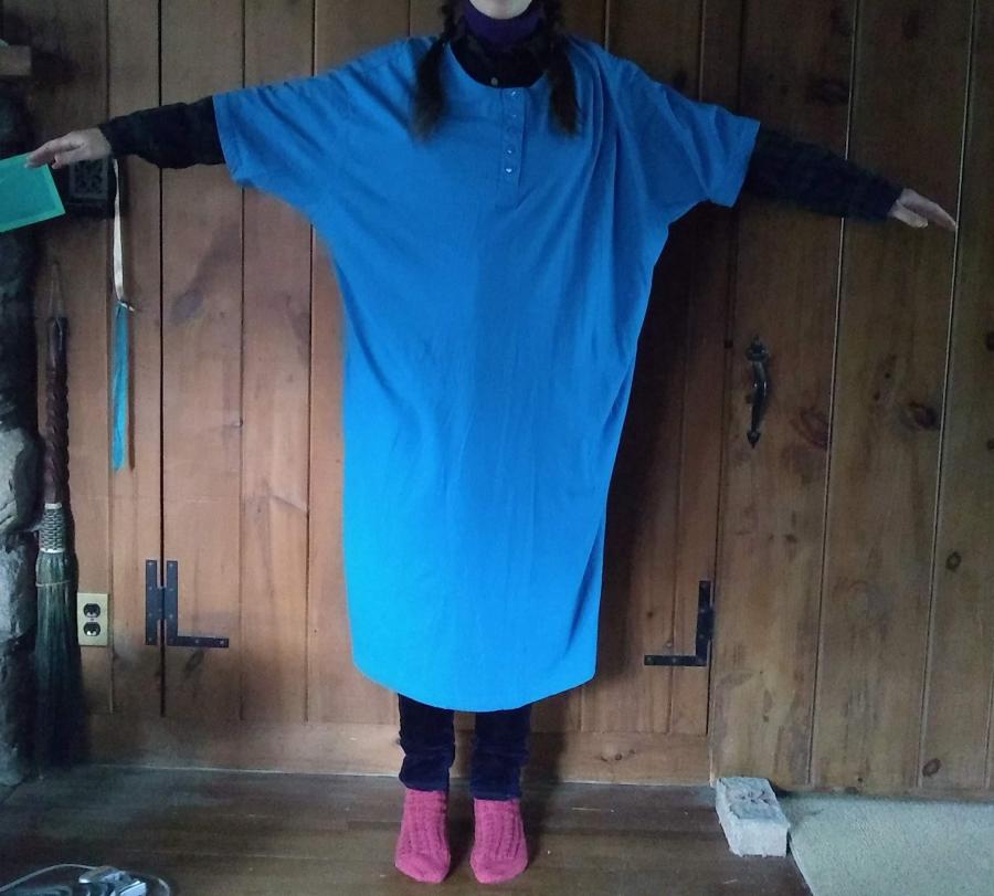 full body front view, arms outstretched, of woman wearing oversize turquoise nightshirt
