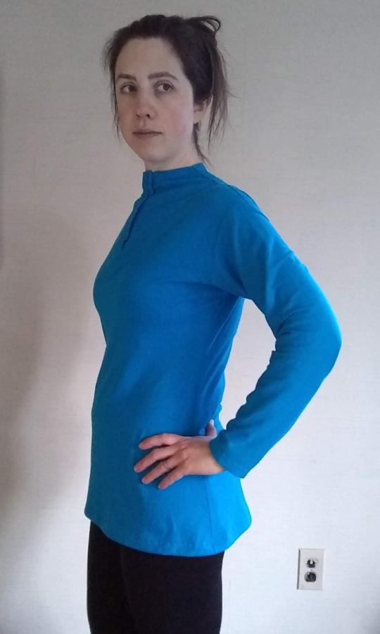 side view of woman wearing long sleeve turquoise henley shirt, tunic length with slightly shaped side seams