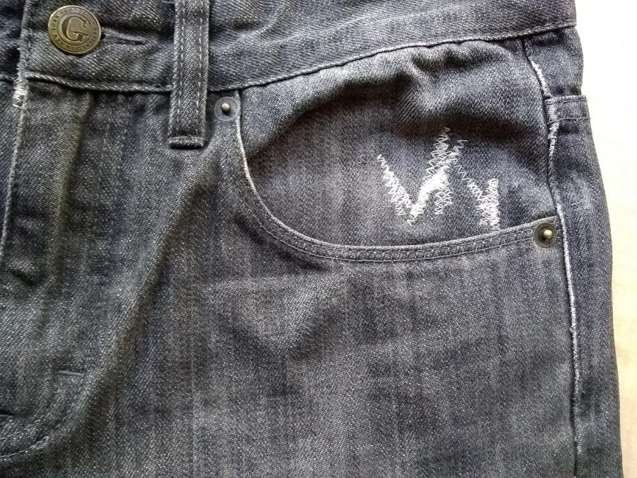 closeup of machine darning at pocket of jeans