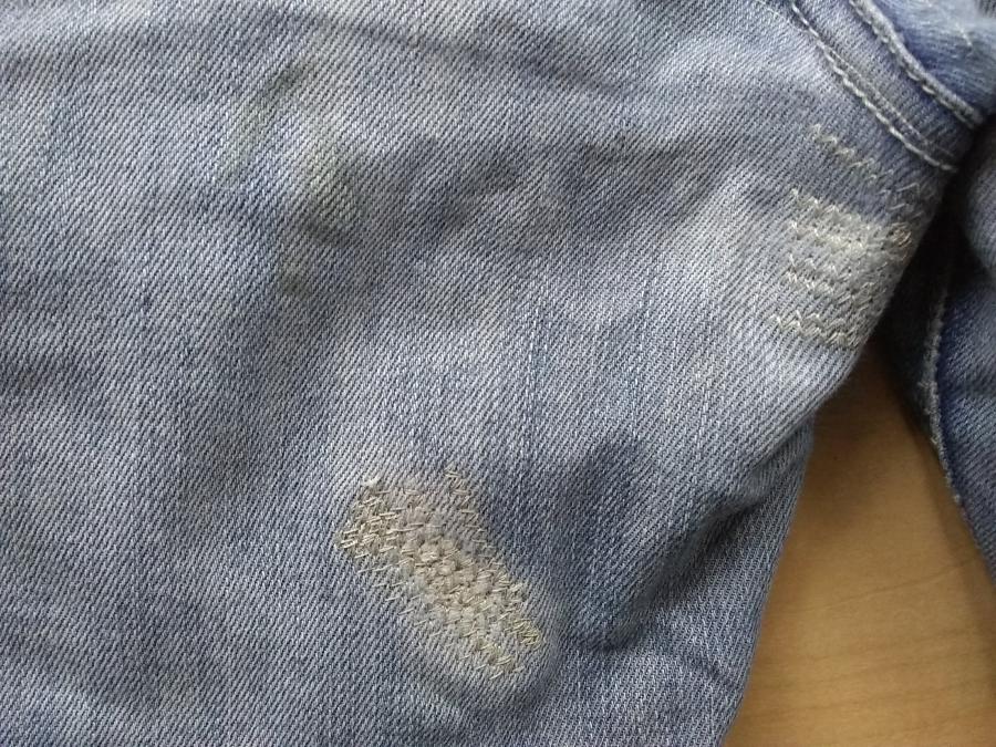 closeup of back inner thigh of pale blue jeans with white machine darning
