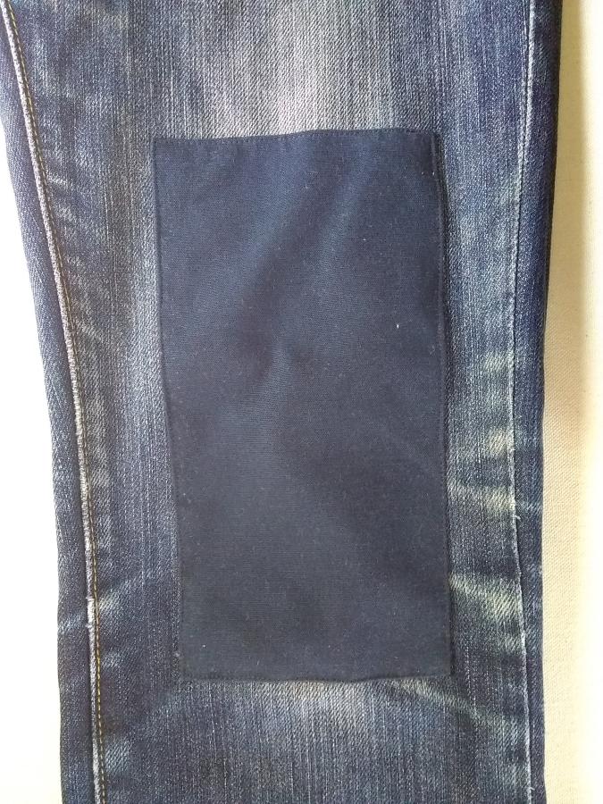 Closeup of jeans knee with large navy patch
