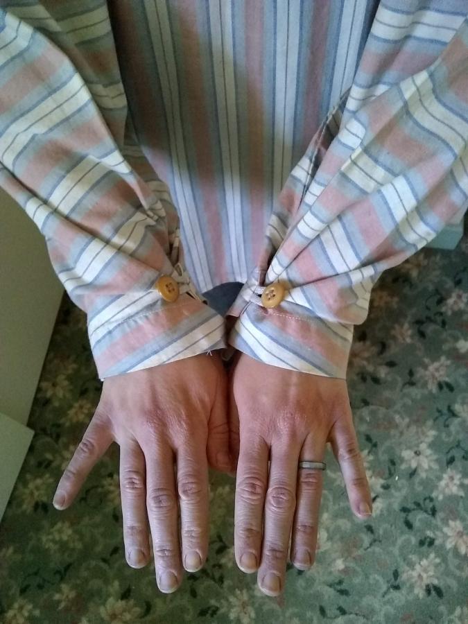 woman's hands and arms in shirt with buttoned up sleeves
