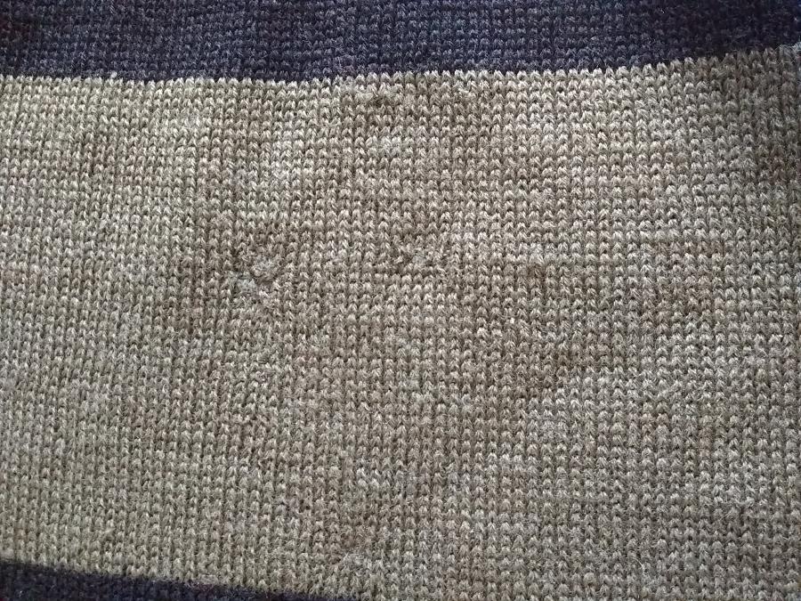 closeup of front of sweater, olive part, showing close to invisible mends