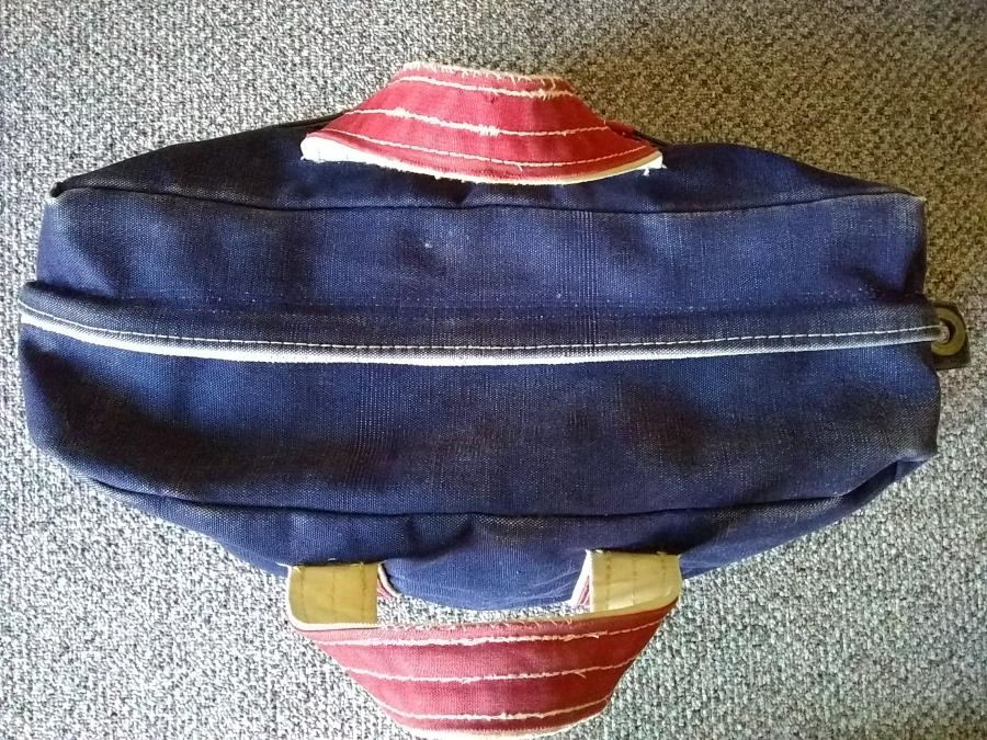 Blue tote bag with red handles, closed, top view