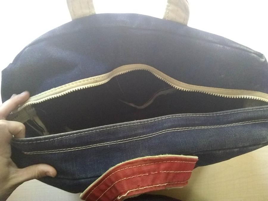 blue tote bag with red handles and broken zipper (zipper shown open)