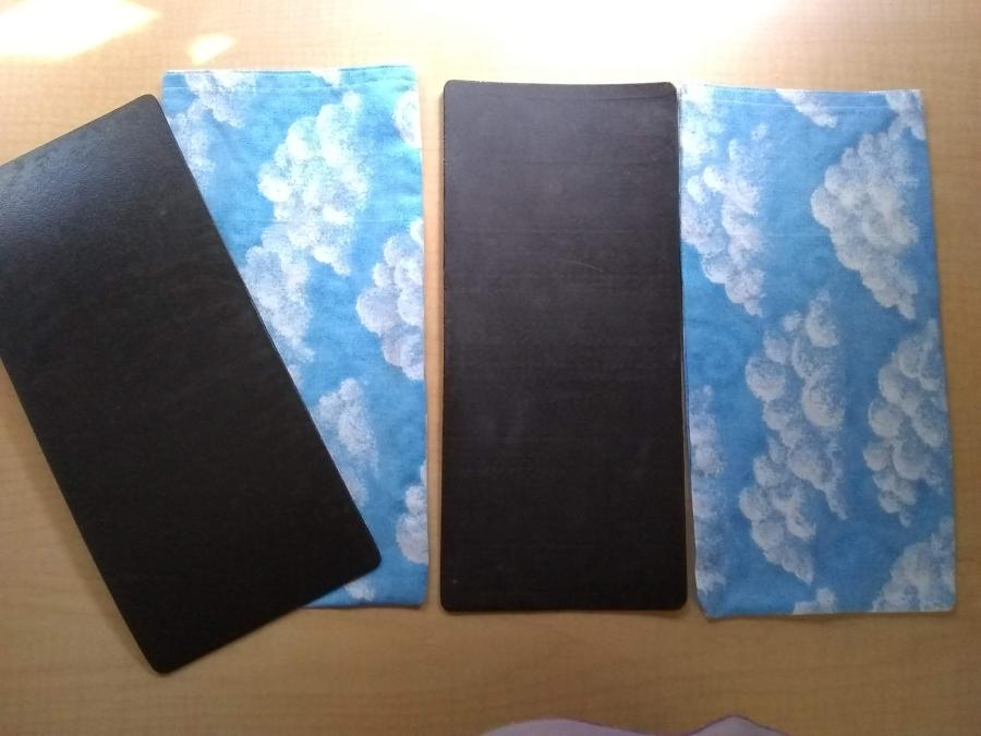 black plastic rectangles with cloth blue cloud print covers in the same size