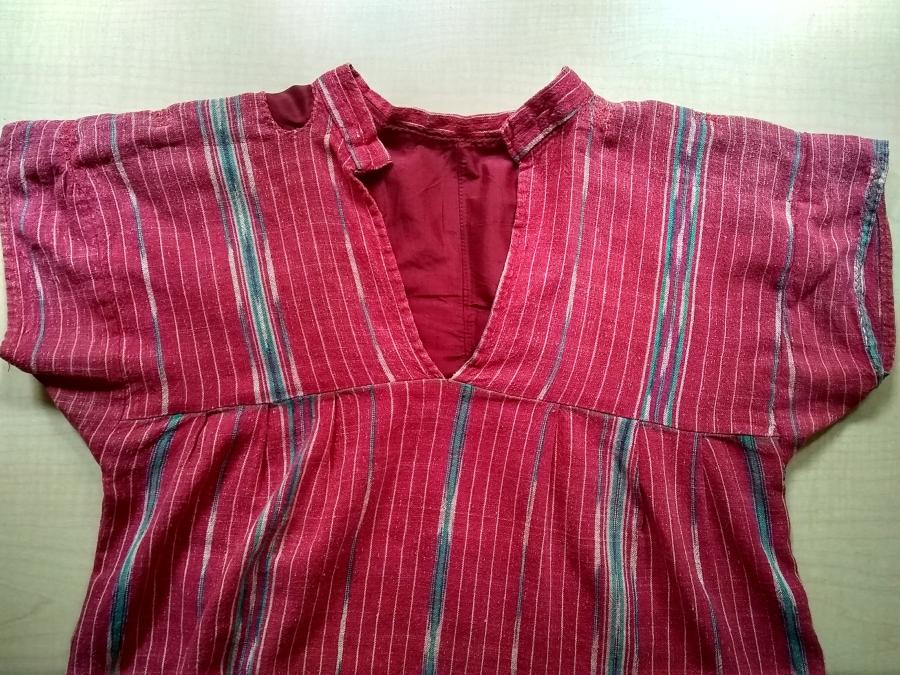 front view of bodice of red striped dress with semi-visible mending: red patches at shoulder and inside, visible through neck slit