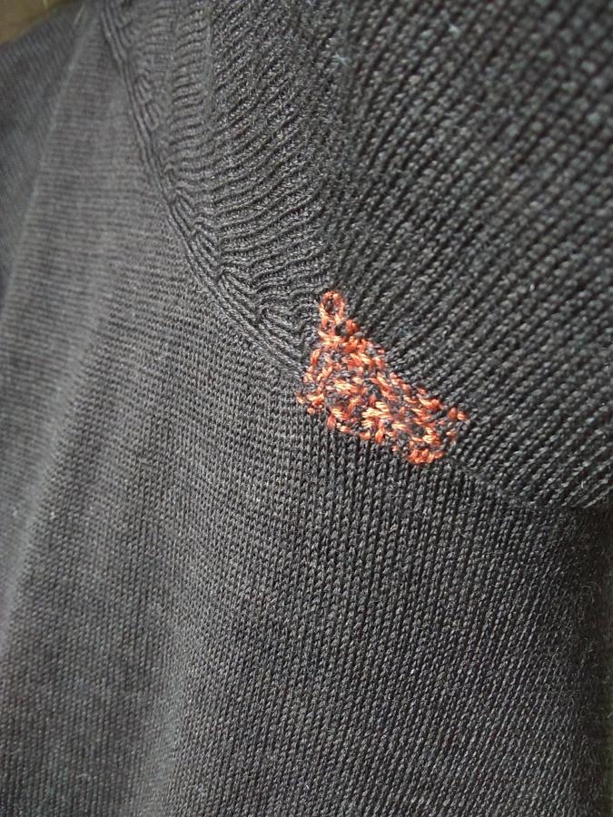 Closeup of darn on armpit of brown sweater (visible darn -- persimmon colored)