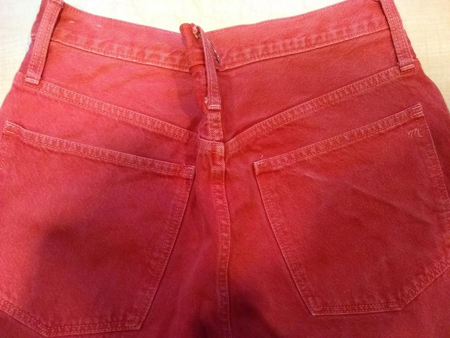 seat of red jeans with a couple of safety pins in the center making the waist/hip smaller