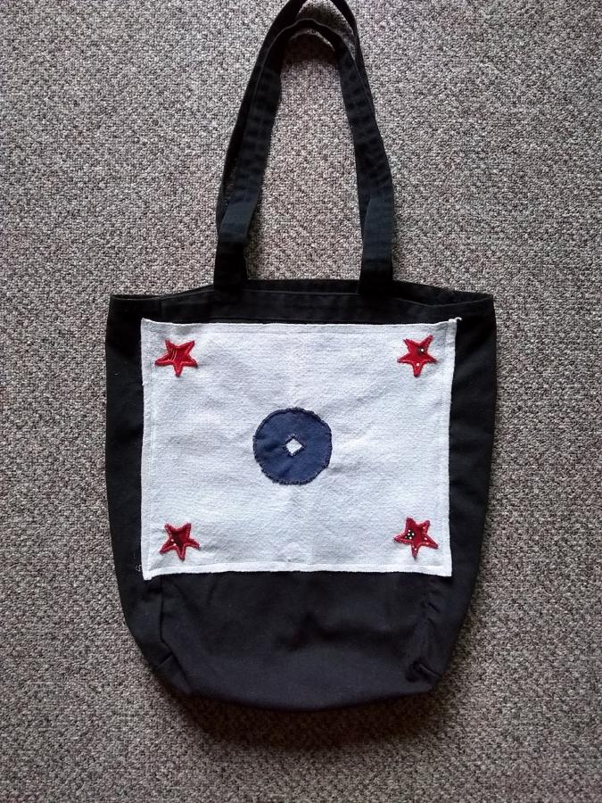 black tote bag with a mostly white (and red and blue) flag patch/pocket sewn onto it