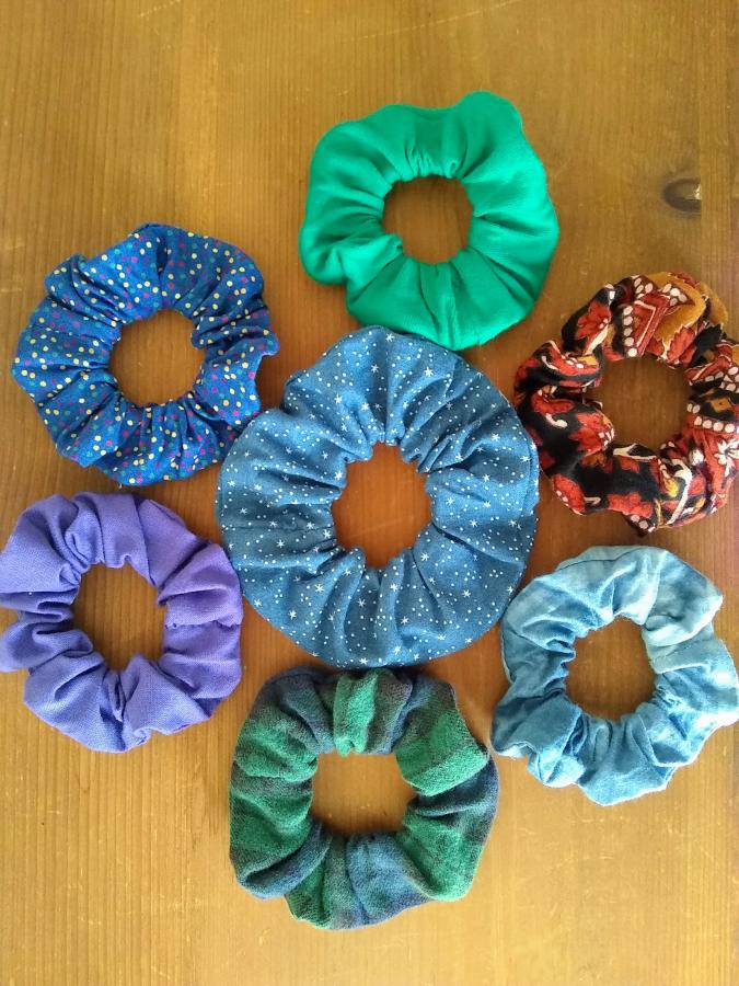 Seven different colored scrunchies on wood background