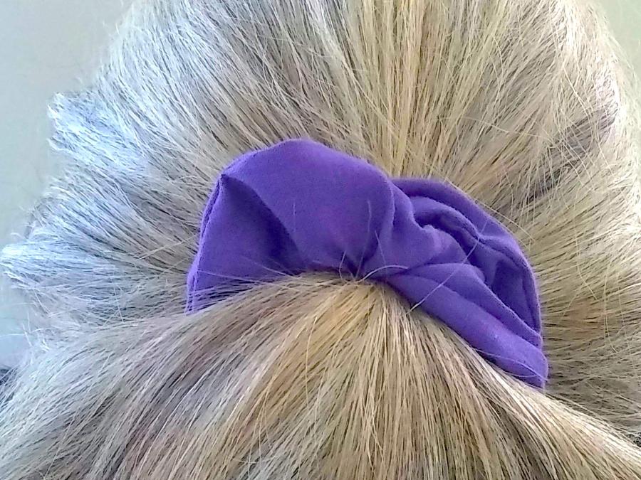 back of woman's hair (gray) wearing purple scrunchie