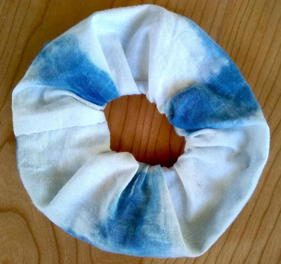 white/blue tie-dye scrunchie on a wood background