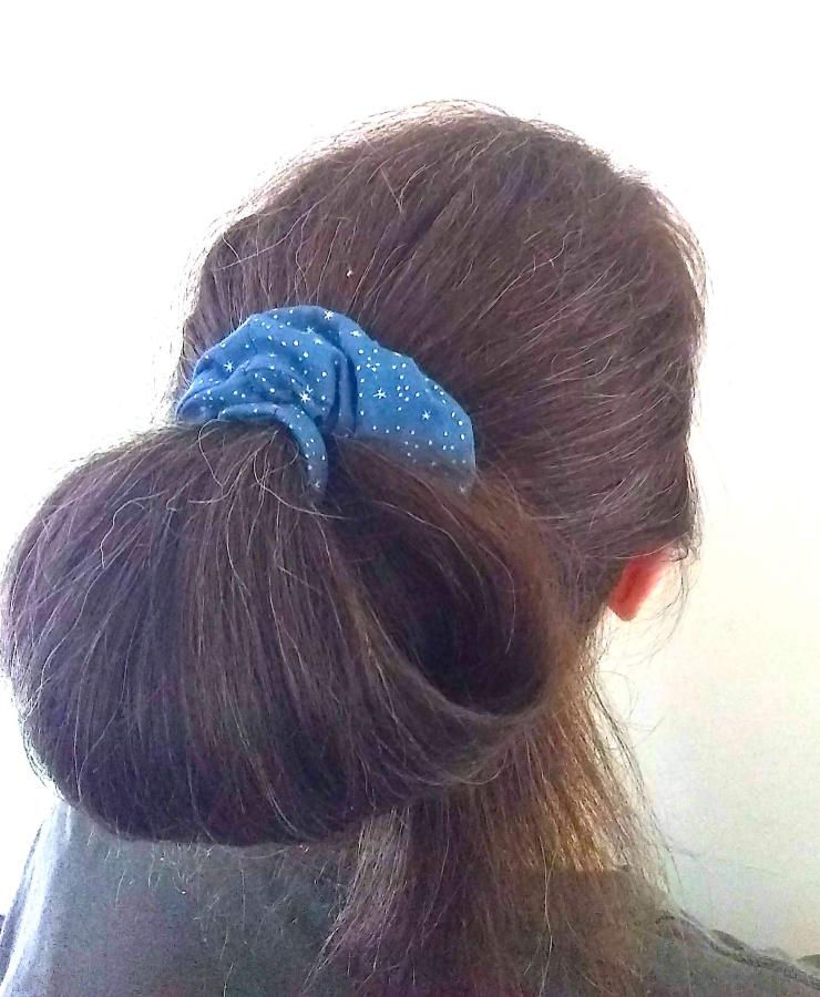 back of woman's hair (brown) wearing puffy blue star print scrunchie