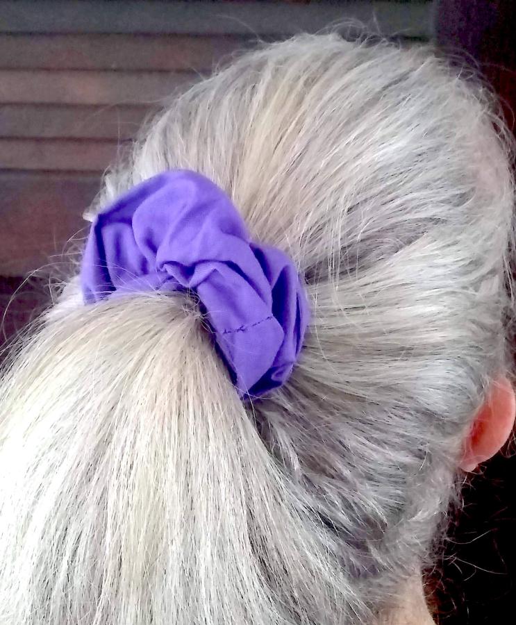 back of woman's hair (gray) modeling puffy purple scrunchie