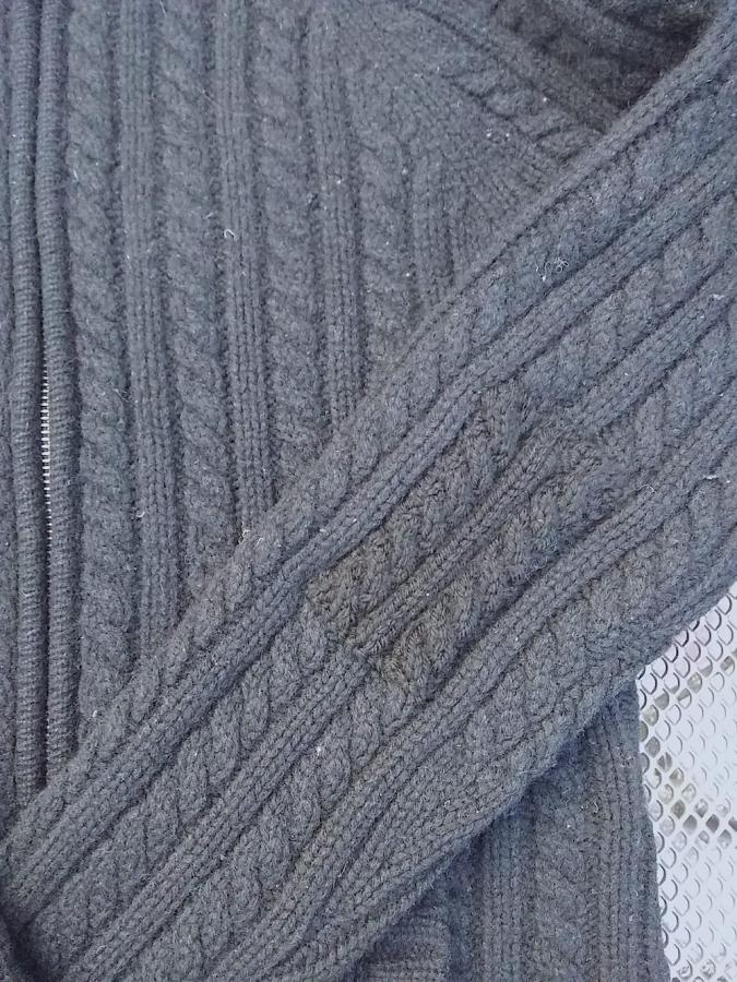 closeup of black cabled sweater with matched black cabled patch on one arm
