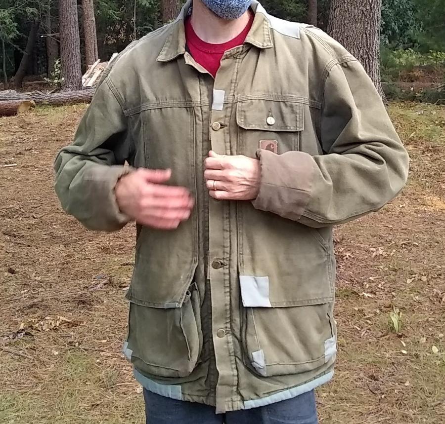 Carhart jacket with many patches worn by a man