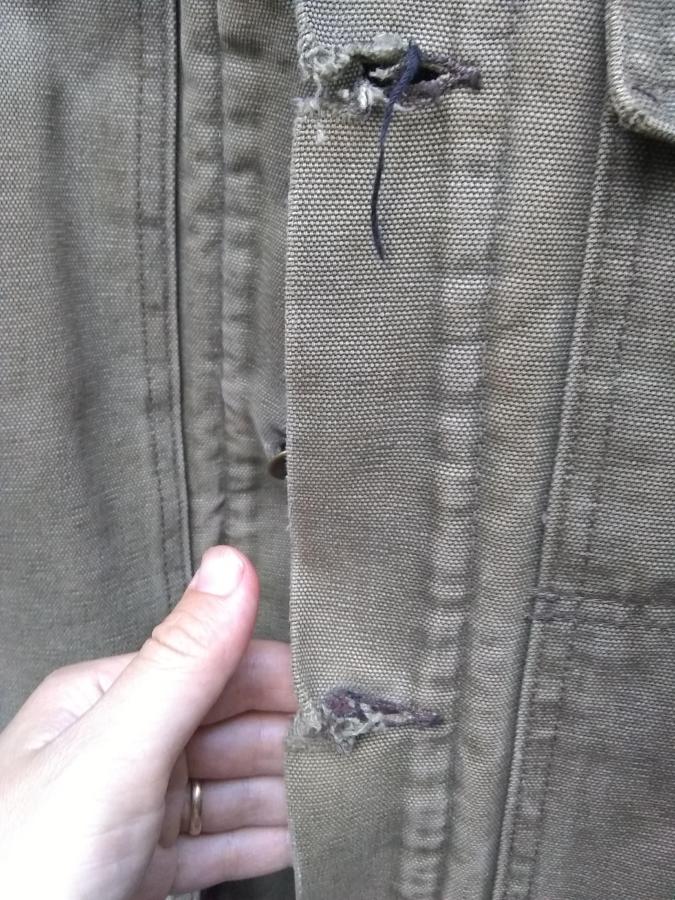 closeup of worn buttonholes on jacket