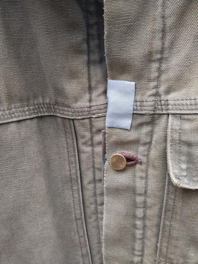closeup view of mended buttonhole and small patch on front of Carhartt jacket