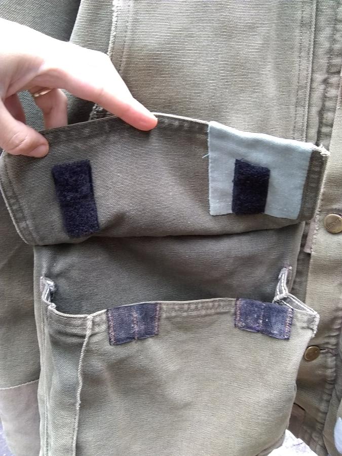 closeup of open pocket of Carhartt jacket showing patch around velcro
