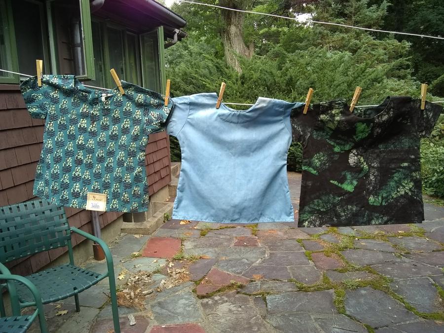 front view of three child's shirts on clothesline