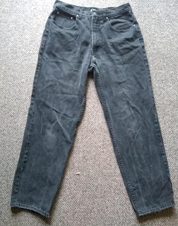 black work jeans with holes in the crotch on gray rug