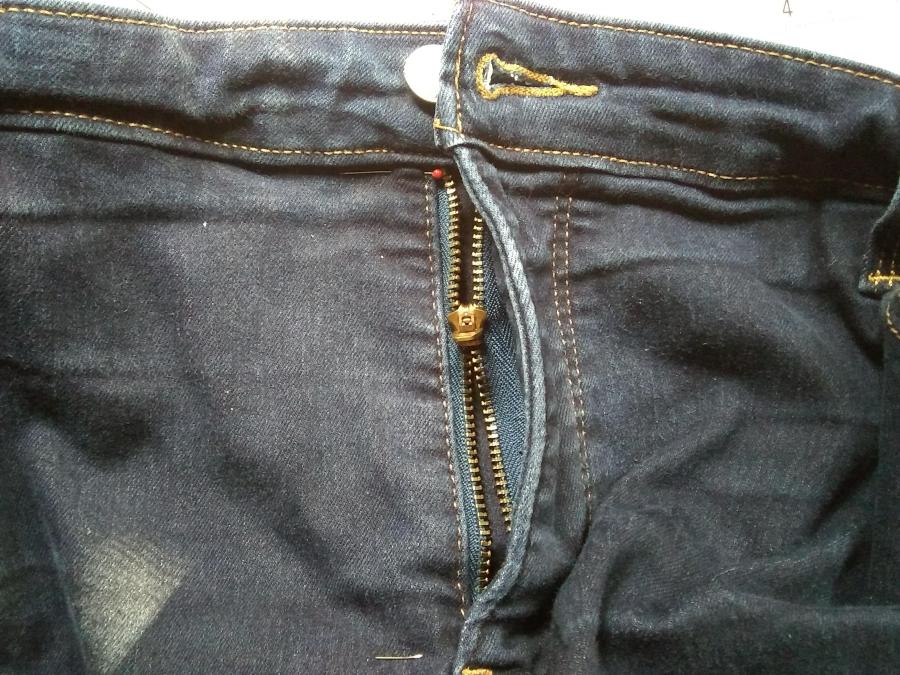 closeup of pair of jeans with broken zipper