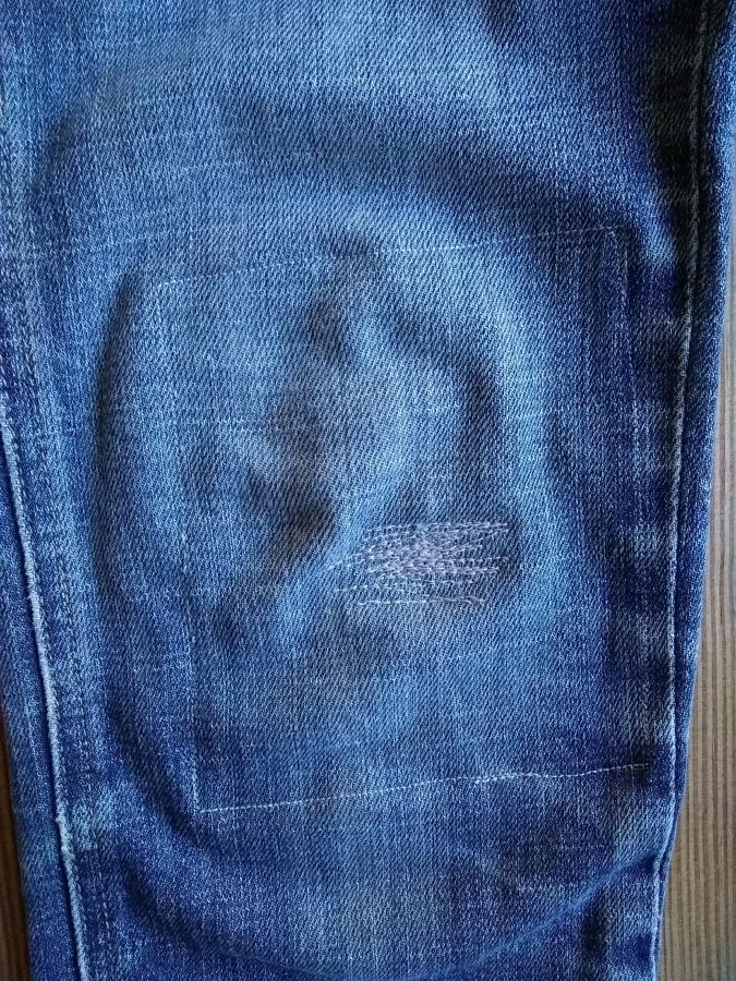 closeup of knee of jeans with interior patch and machine darning