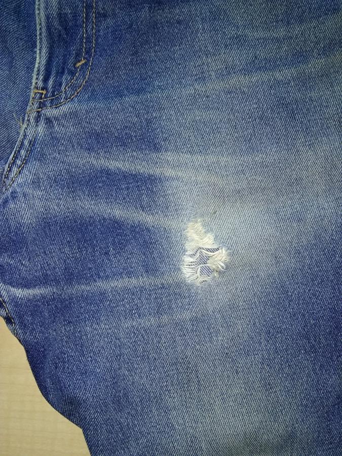 closeup of hole on right upper thigh of jeans