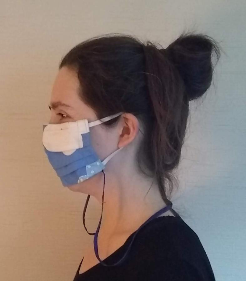Side view of woman wearing pleated mask with neck cord