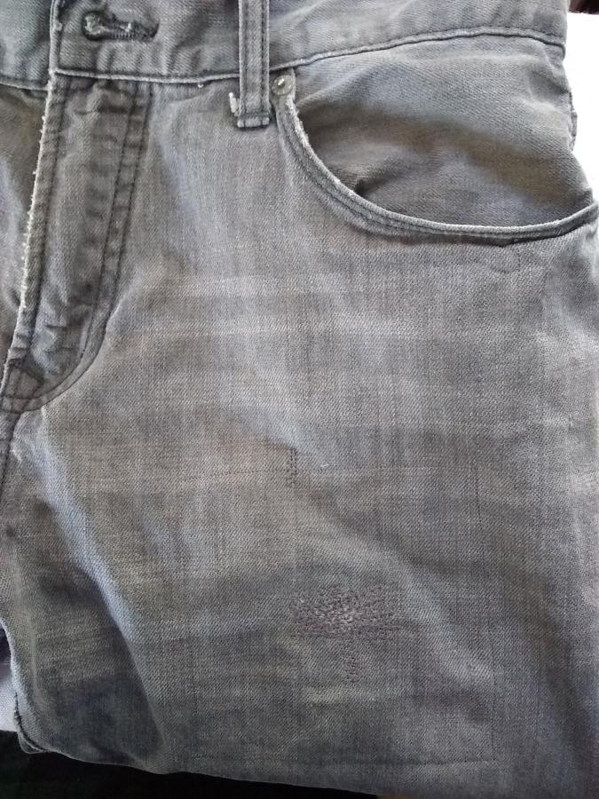side front of jeans, showing close to invisible mend at upper thigh