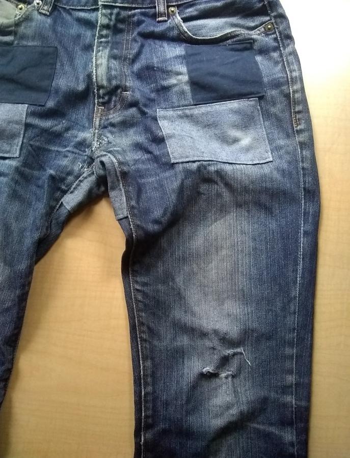 blue jeans with patches at hips and new hole at knee