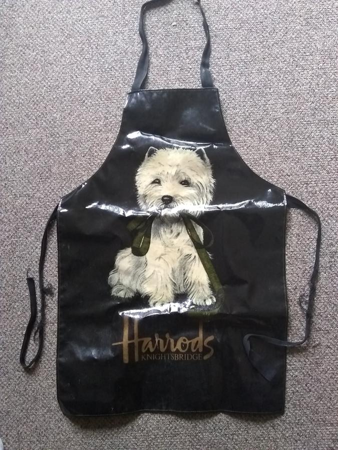 black apron with dog on front and frayed waist sashes