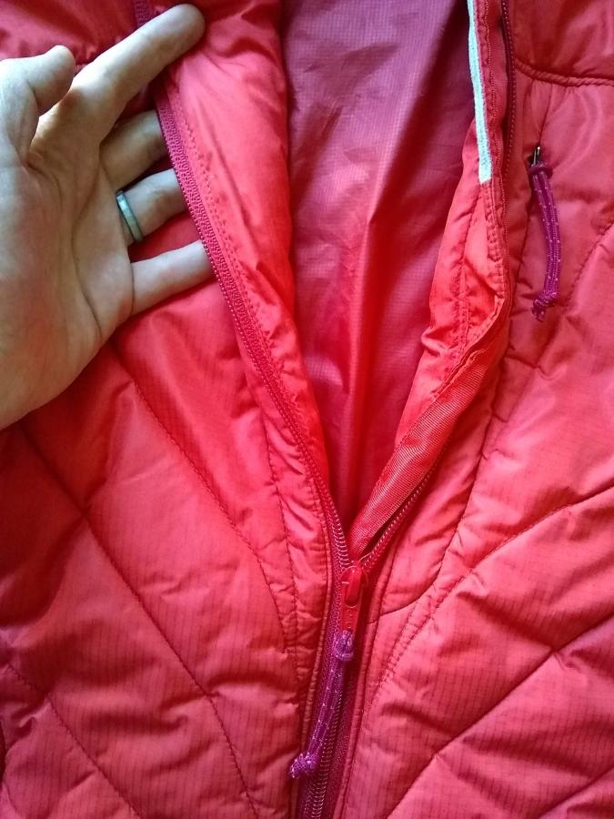 red winter jacket with replaced zipper, partially unzipped, pulled open to show lining and inside of jacket