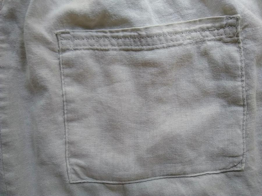 Patch style pocket on back of off white linen pants. the pocket is actually a faux pocket (it is sewn shut at the top and has no lining) but you can't tell from the picture