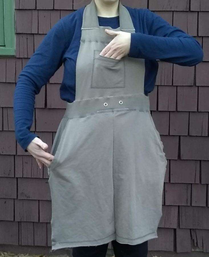 Woman wearing upcycled apron with hands in pockets