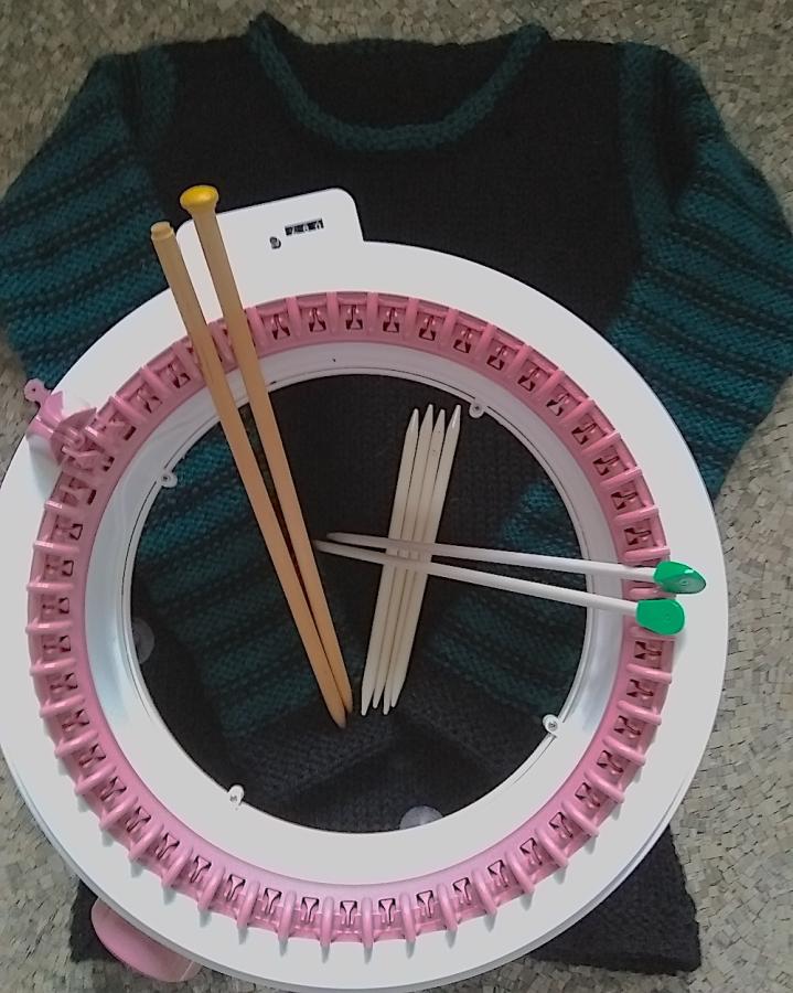 circular knitted machine and knitting needles on top of a sweater
